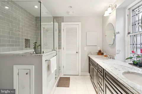 a bathroom with a granite countertop sink a mirror and a shower