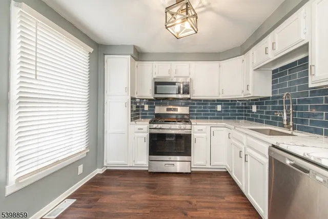 a kitchen with stainless steel appliances a stove a sink and a microwave