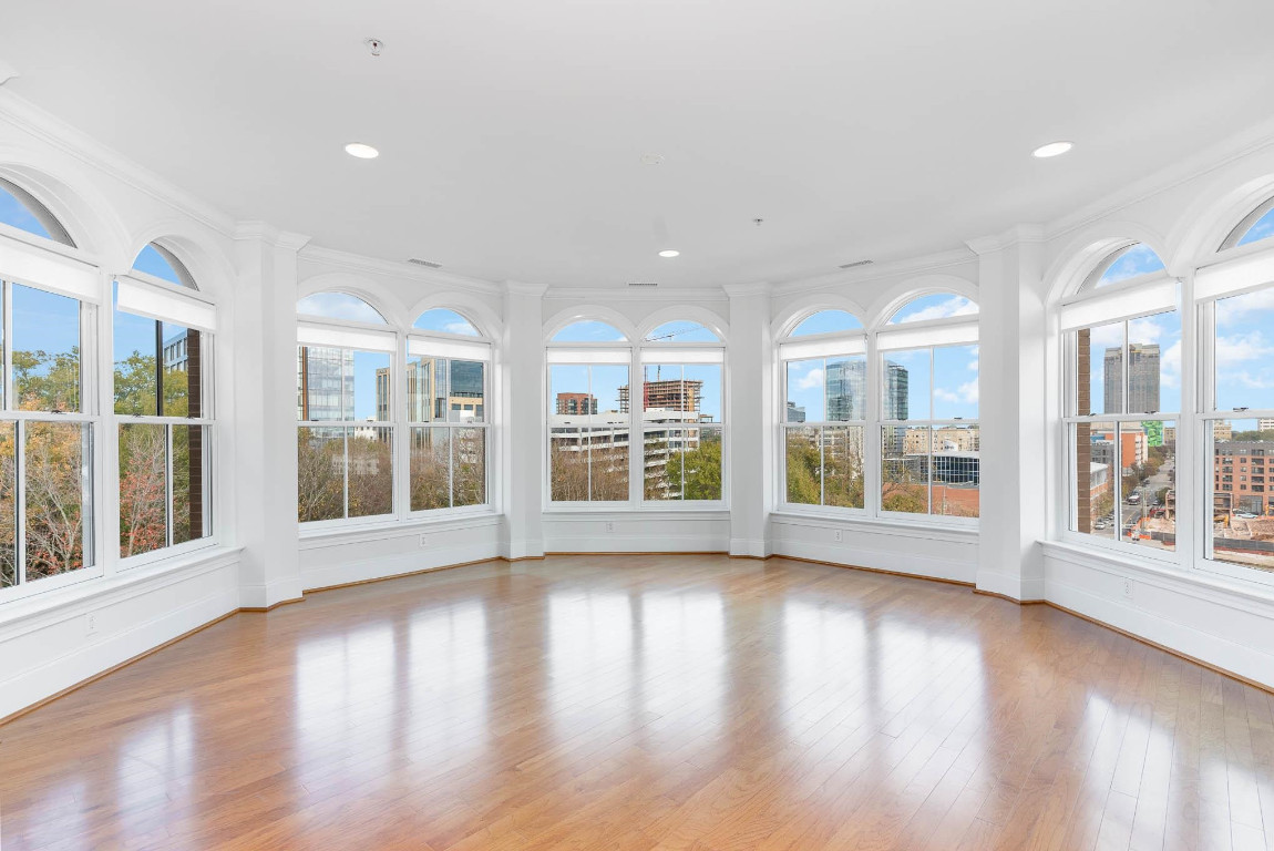 710 Independence Place, Unit 606 Raleigh, NC 27603 - Photo 3 of 21 a view of an empty room with wooden floor and windows