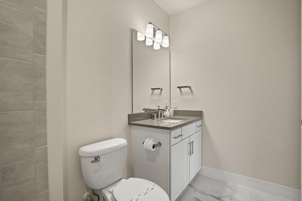 8352 Pk Clf Way Orlando, FL 32836 - Photo 39 of 55 a bathroom with a granite countertop toilet a sink and mirror