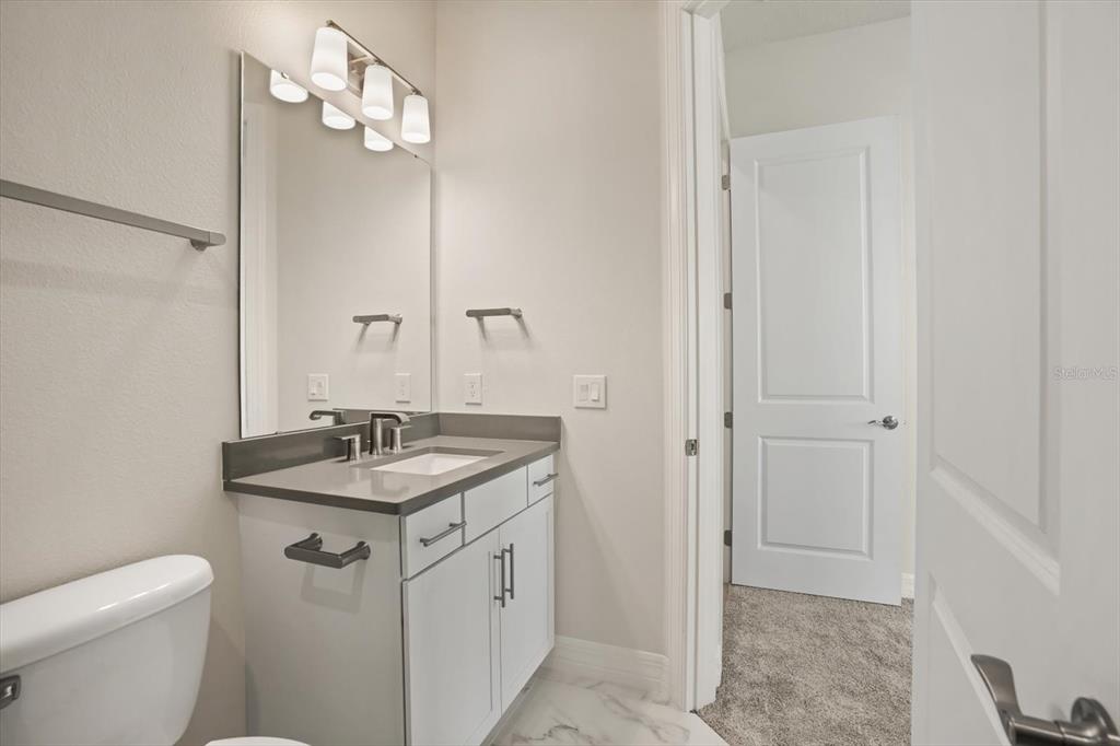 8352 Pk Clf Way Orlando, FL 32836 - Photo 41 of 55 a bathroom with a granite countertop sink a toilet and a mirror