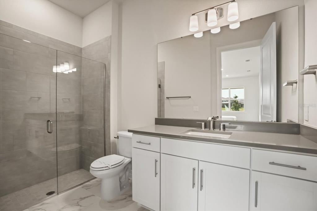 8352 Pk Clf Way Orlando, FL 32836 - Photo 42 of 55 a bathroom with a granite countertop sink a toilet and a mirror
