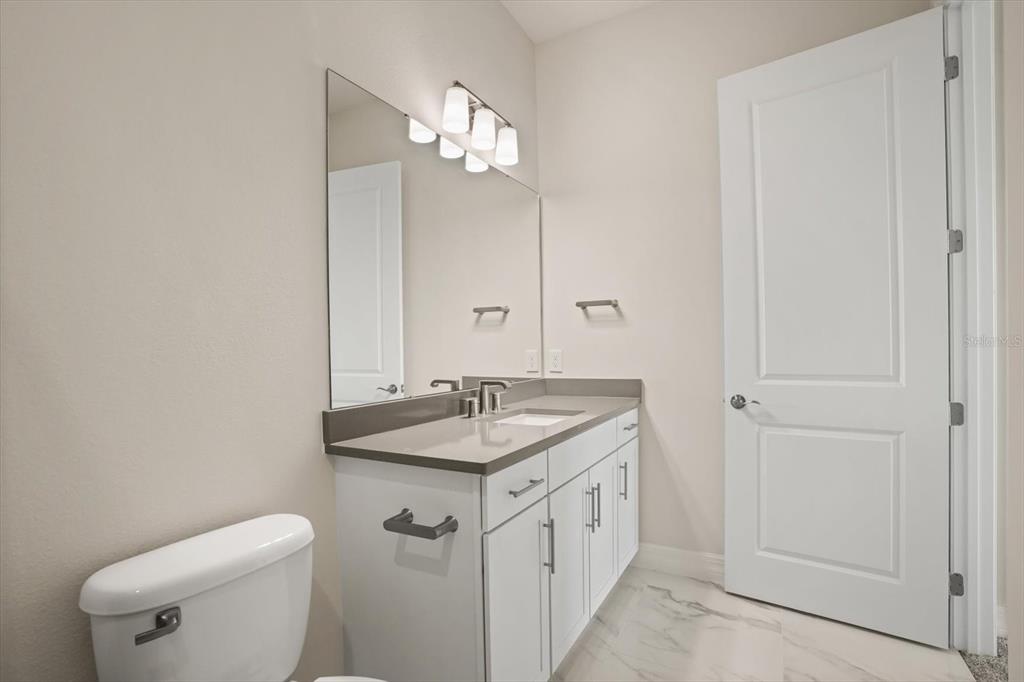8352 Pk Clf Way Orlando, FL 32836 - Photo 43 of 55 a bathroom with a granite countertop sink a toilet and a mirror