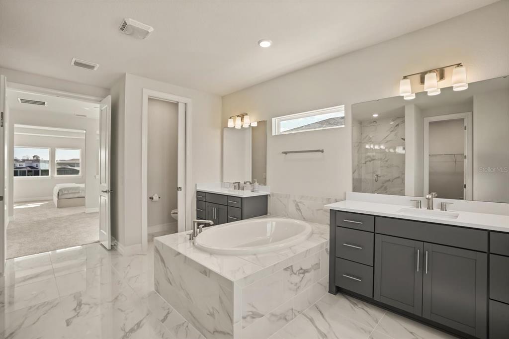 8352 Pk Clf Way Orlando, FL 32836 - Photo 44 of 55 a bathroom with a sink double vanity granite tub shower and a mirror
