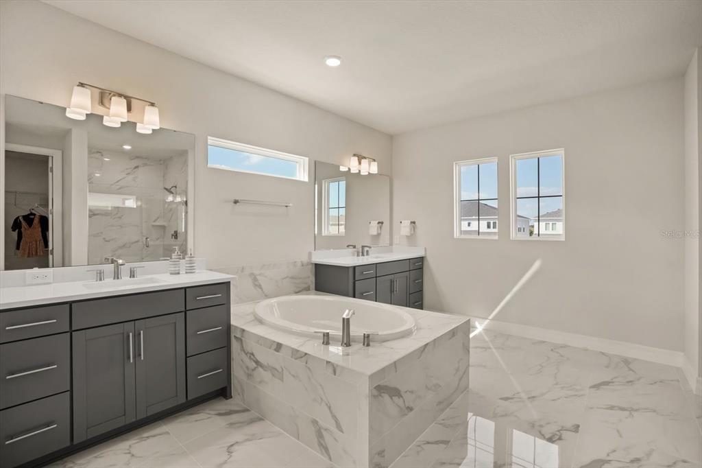 8352 Pk Clf Way Orlando, FL 32836 - Photo 45 of 55 a bathroom with a sink a bathtub a mirror and a vanity