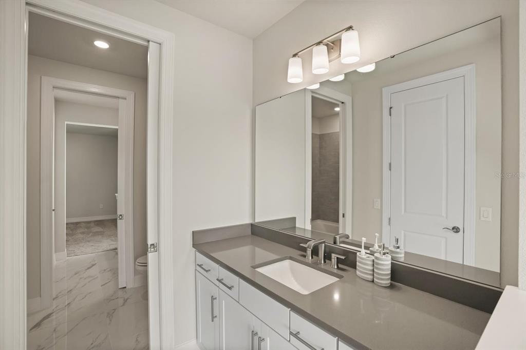 8352 Pk Clf Way Orlando, FL 32836 - Photo 47 of 55 a bathroom with a double vanity sink and a mirror
