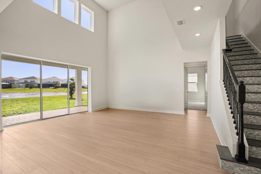 8352 Pk Clf Way Orlando, FL 32836 - Photo 7 of 55 a view of an empty room with wooden floor and a floor to ceiling window