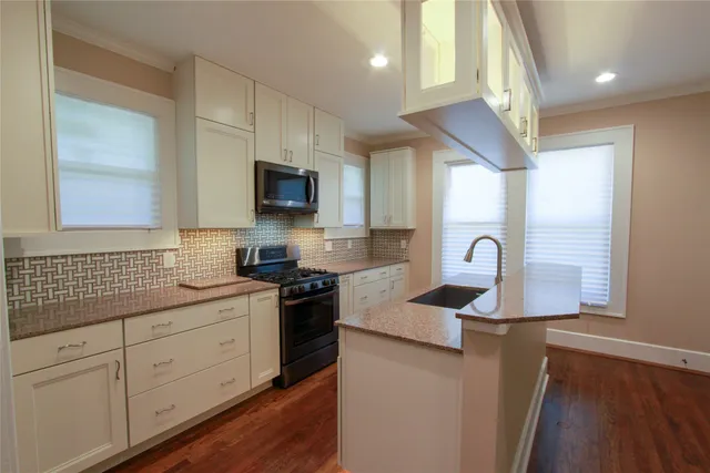 a kitchen with stainless steel appliances granite countertop a sink a stove a refrigerator a microwave and cabinets