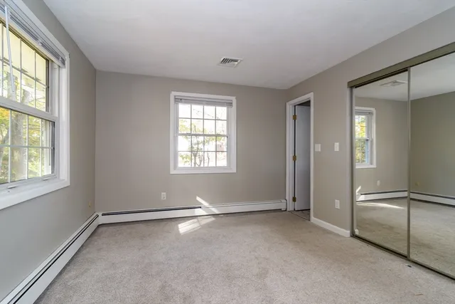 an empty room with windows and closet