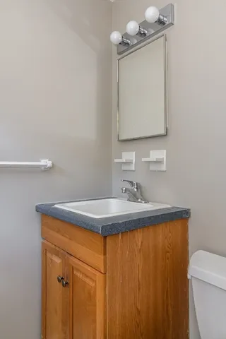 a bathroom with a sink a toilet and mirror