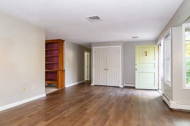an empty room with wooden floor and closet