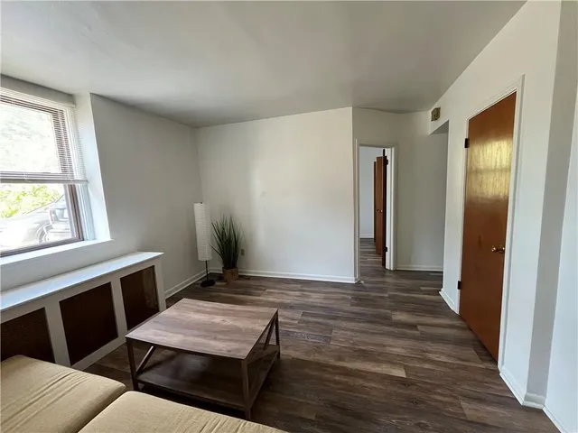 a view of a hallway with furniture and wooden floor