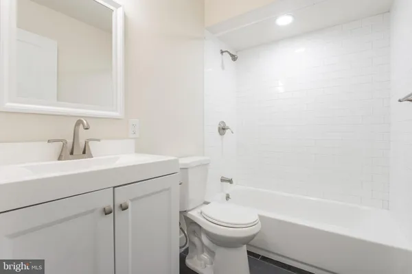 a bathroom with a sink toilet vanity and bathtub
