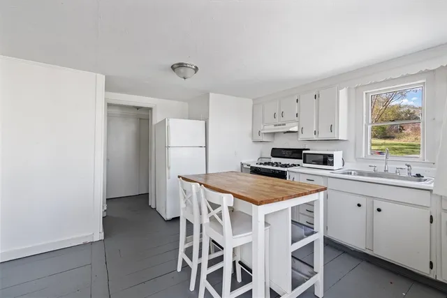 a kitchen with stainless steel appliances a stove a sink refrigerator and a window