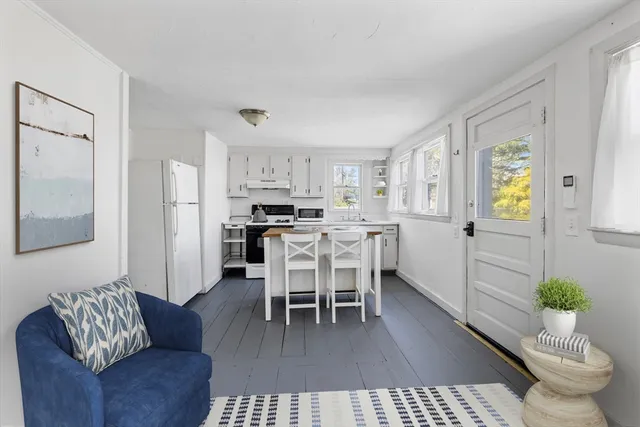 a living room with furniture and a dining table with kitchen view