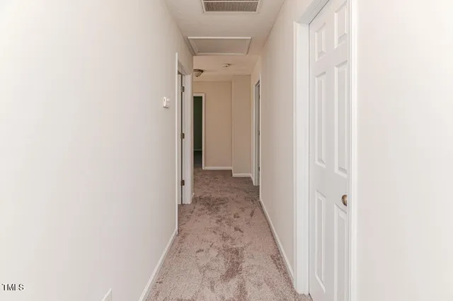 an empty room with windows and chandelier fan