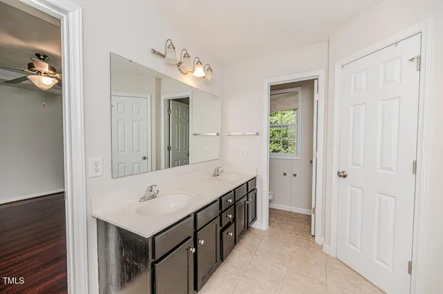 a spacious bathroom with a bathtub shower sink double vanity and a mirror
