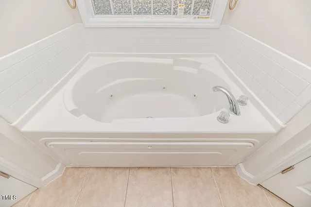 an empty room with wooden floor ceiling fan and windows