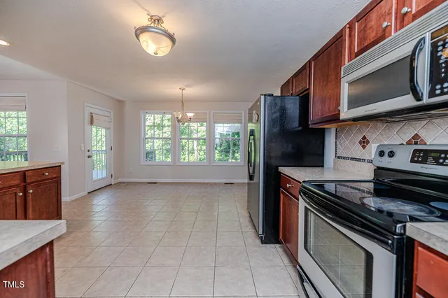 a kitchen with stainless steel appliances granite countertop a refrigerator and a stove