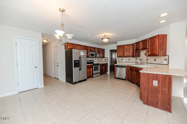 an empty room with windows fireplace and wooden floor