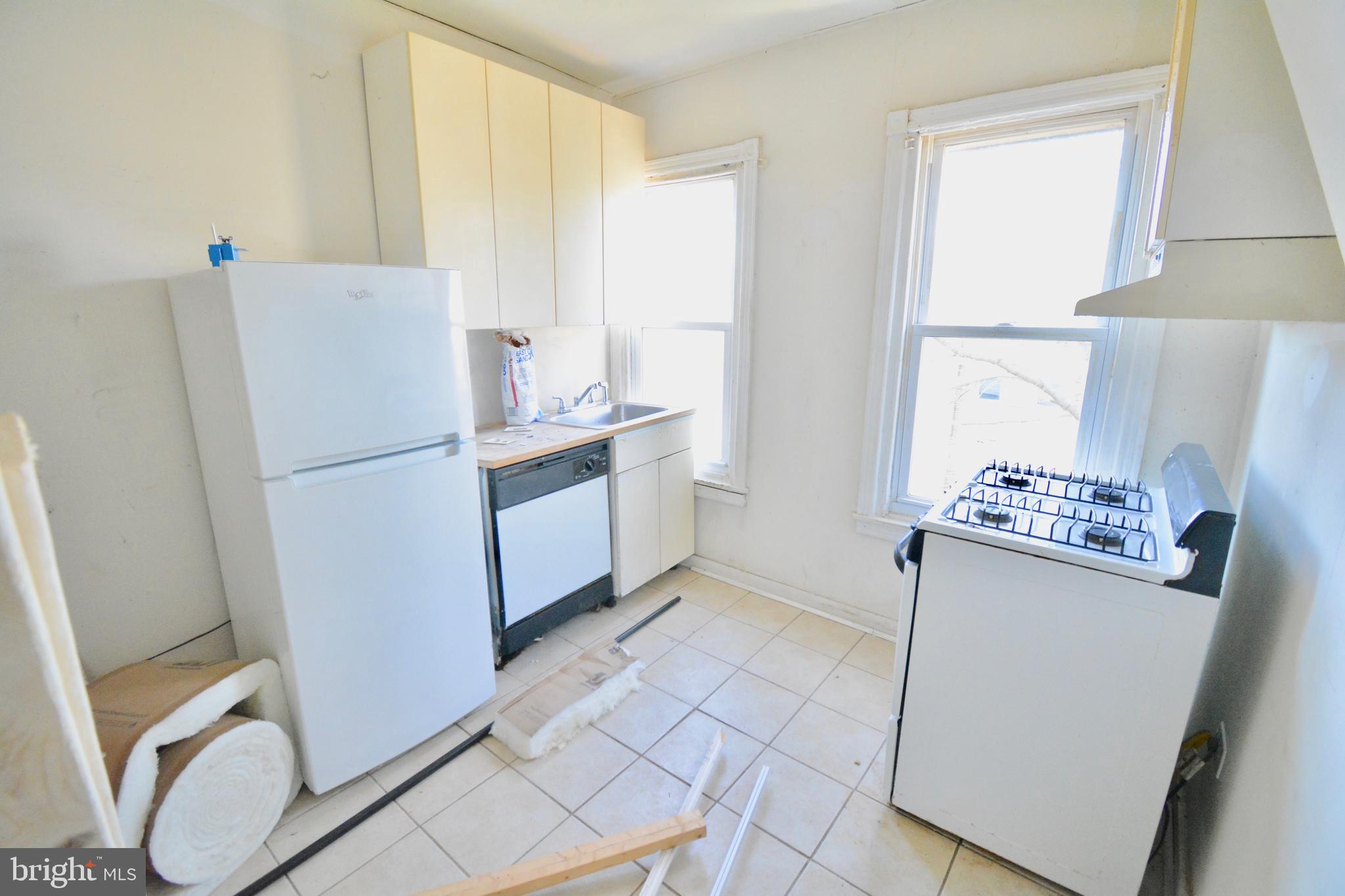 433 Hansberry Street, Unit 3 Philadelphia, PA 19144 - Photo 9 of 12 a kitchen with a refrigerator sink stove and cabinets