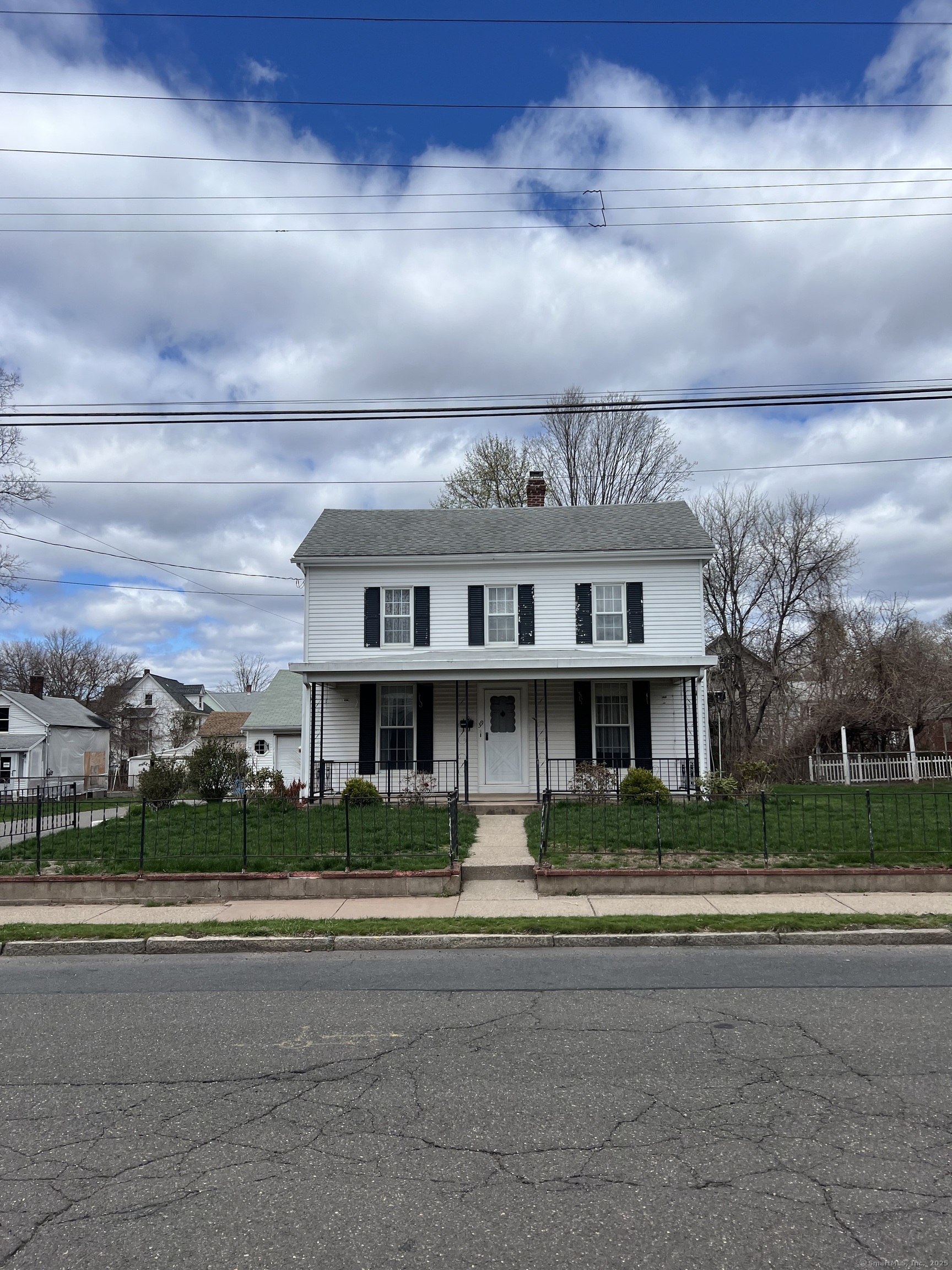 a view of house with a big yard and large trees