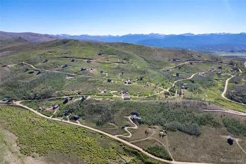 an aerial view of a house with a mountain
