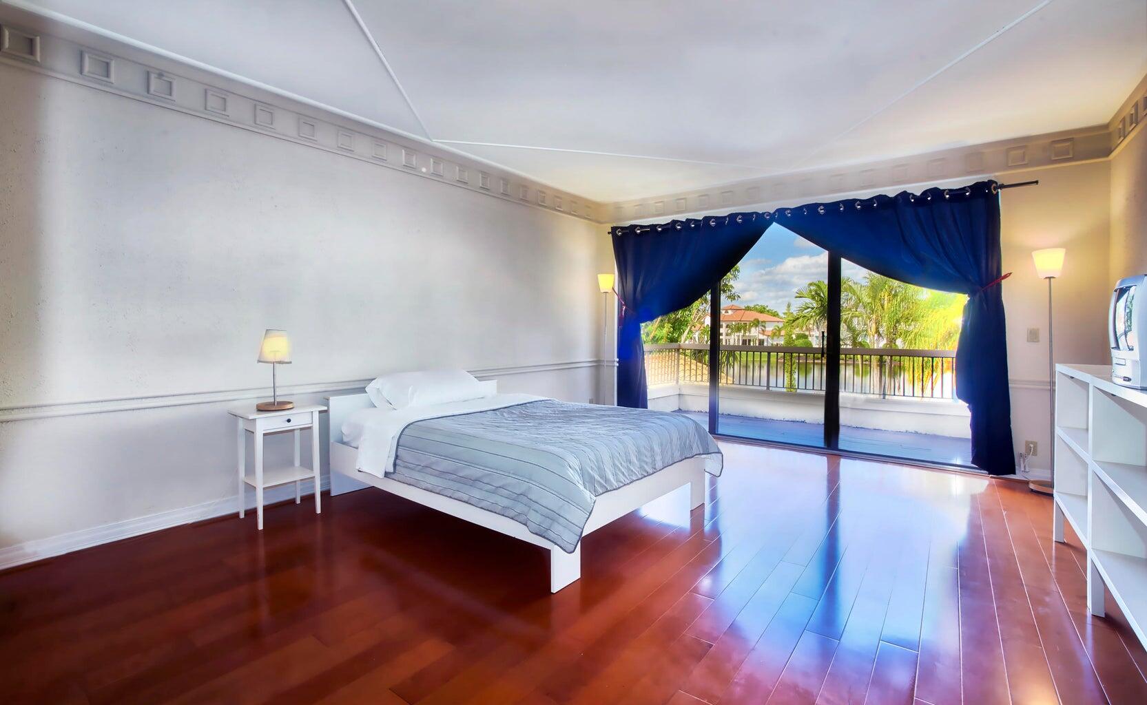 21125 Hamlin Drive Boca Raton, FL 33433 - Photo 28 of 69 a bedroom with a bed and wooden floor