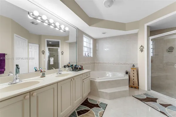 a bathroom with a tub a sink and mirror