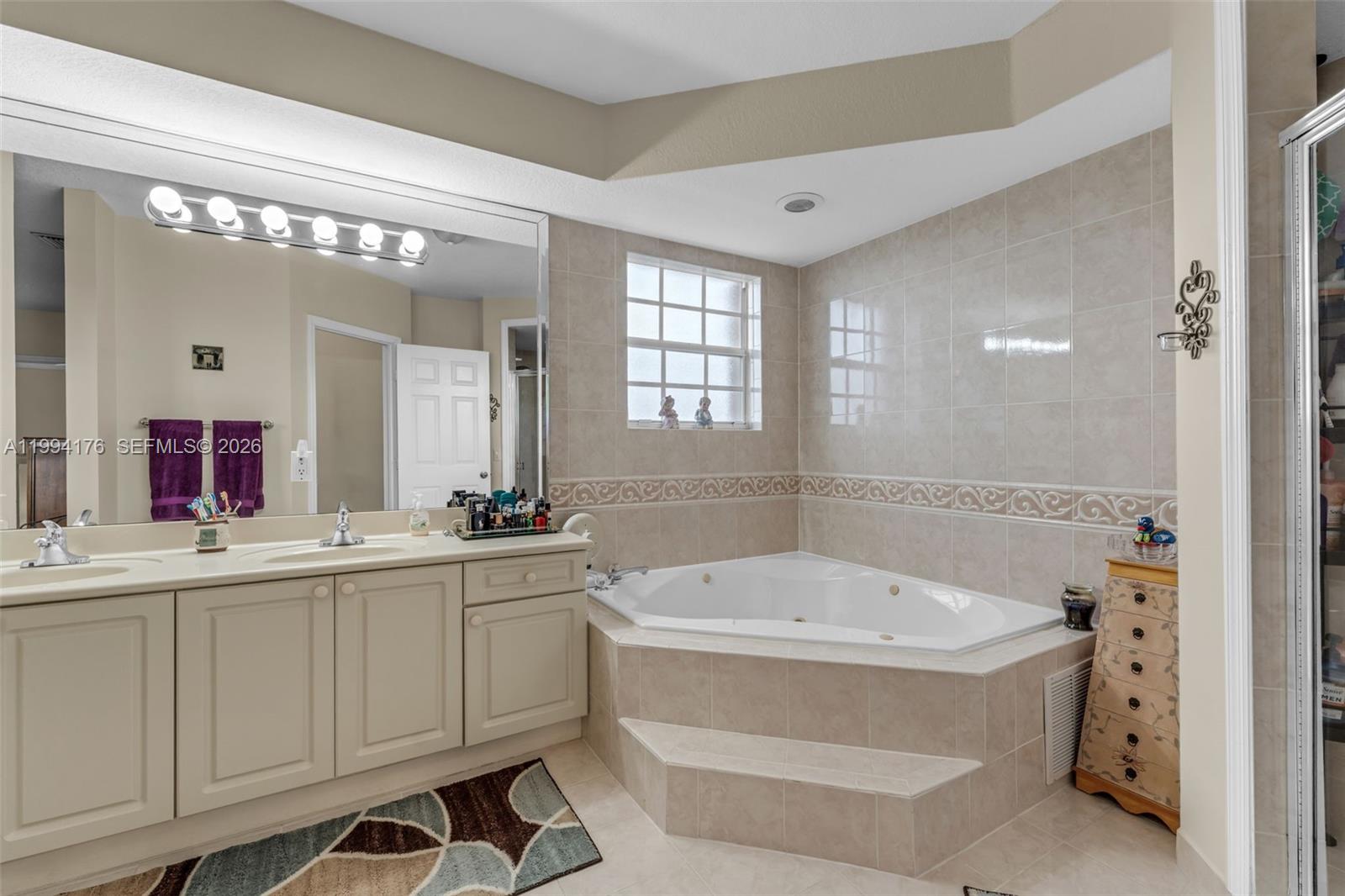 6502 Southwest 157th Court Miami, FL 33193 - Photo 23 of 51 a bathroom with a bathtub a double vanity sink and mirror