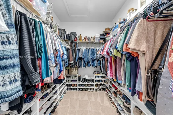 a view of walk in closet with clothes