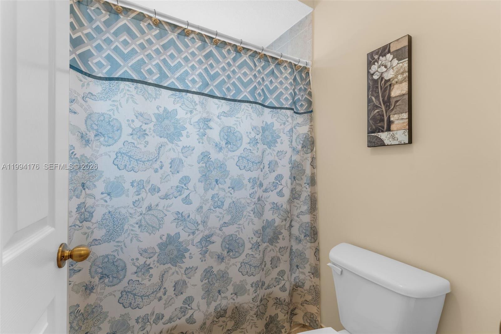 6502 Southwest 157th Court Miami, FL 33193 - Photo 27 of 51 a white toilet sitting next to a shower curtain