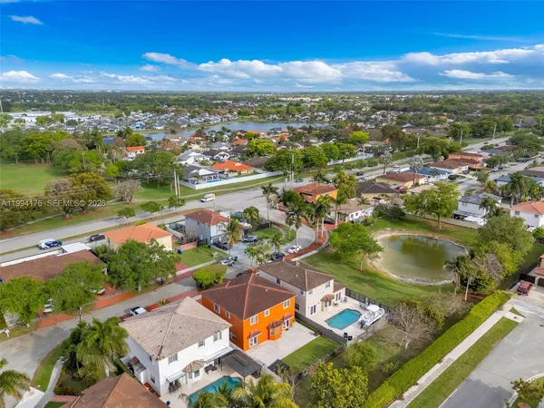an aerial view of residential houses with outdoor space and lake view
