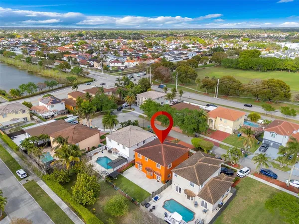 an aerial view of residential houses with outdoor space and ocean view