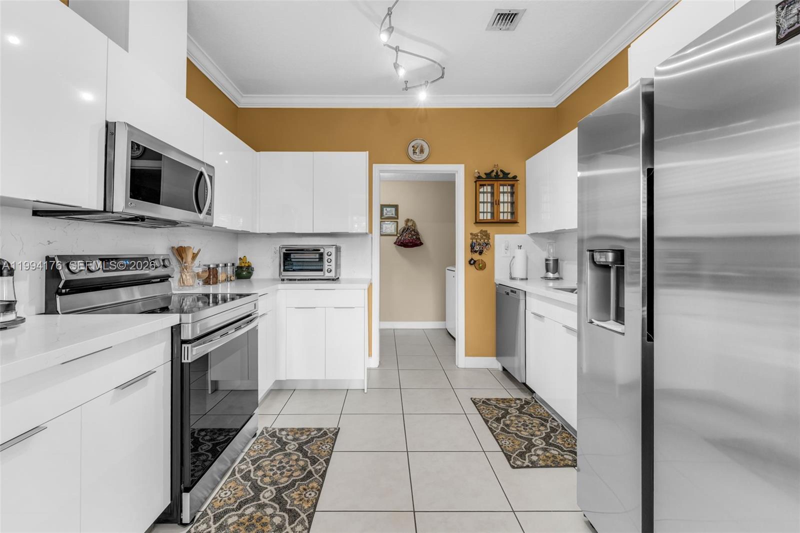 6502 Southwest 157th Court Miami, FL 33193 - Photo 8 of 51 a kitchen with stainless steel appliances granite countertop a refrigerator and a stove top oven