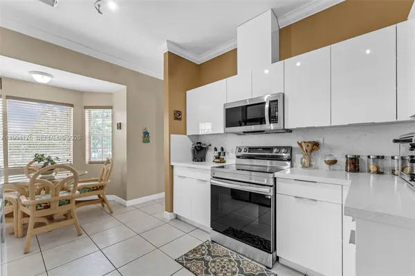 a kitchen with stainless steel appliances a stove a sink cabinets and a refrigerator