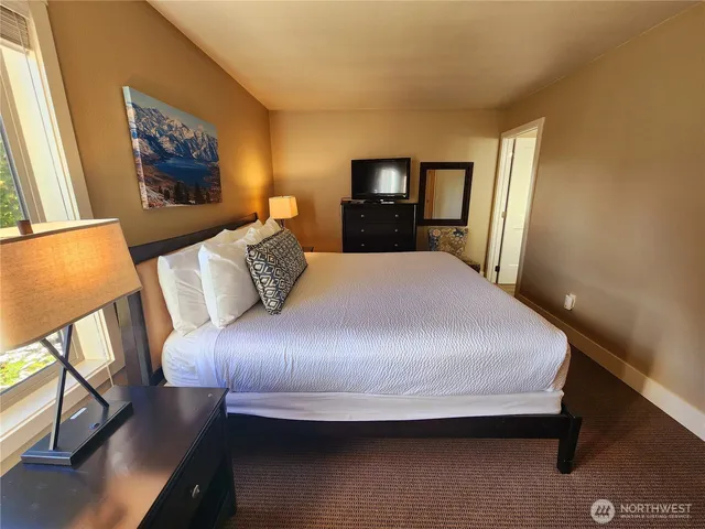 a bed sitting in a bedroom next to a window