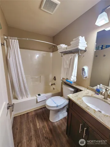 a bathroom with a granite countertop sink toilet and shower