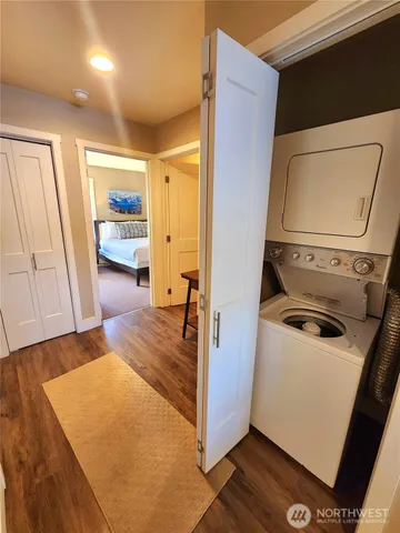 a view of storage and utility room with refrigerator and wooden floor
