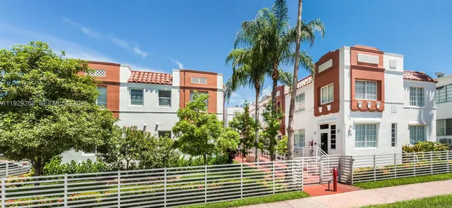 a front view of a multi story residential apartment building with yard and entryway