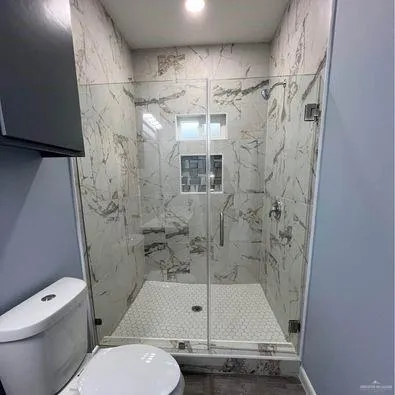 a bathroom with a shower a toilet and a sink