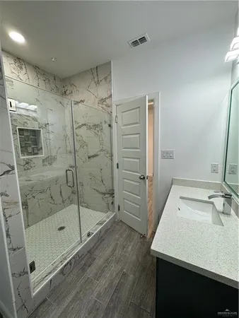 a bathroom with a shower sink and mirror