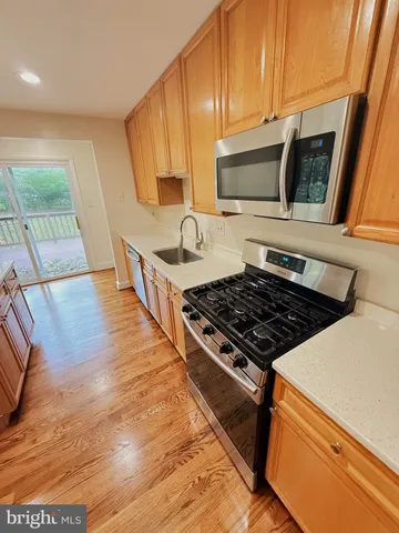 a kitchen with wooden floors and appliances