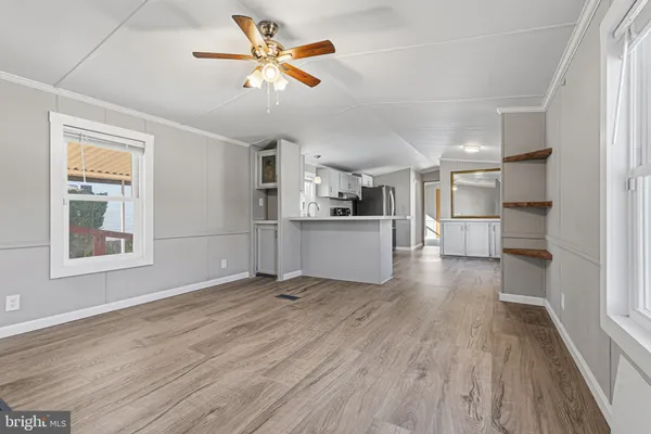 a kitchen with white cabinets and wooden floor