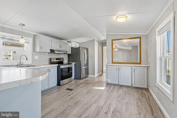 a kitchen with stainless steel appliances a sink stove and cabinets