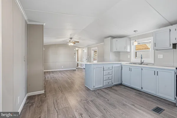 a kitchen with cabinets wooden floor and stainless steel appliances