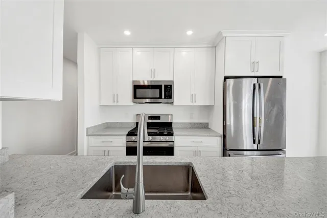 a kitchen with granite countertop a refrigerator and a sink