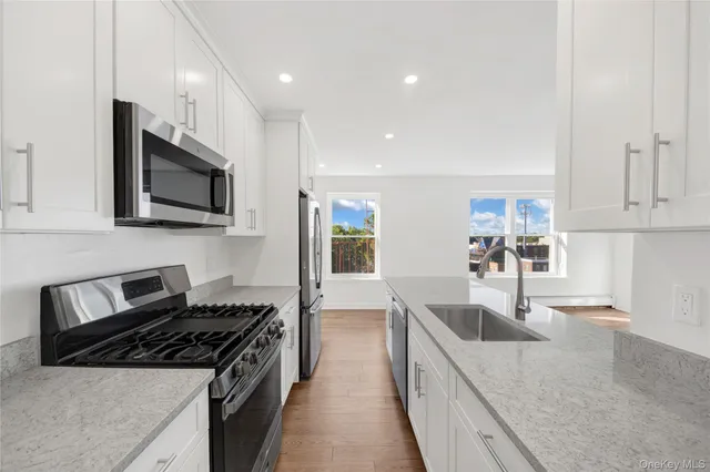 a kitchen with stainless steel appliances granite countertop a refrigerator sink and stove