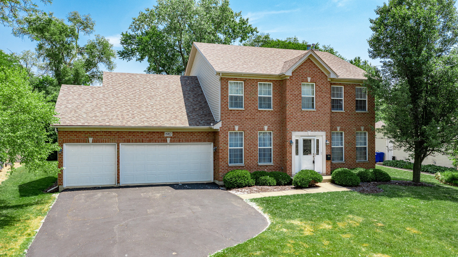 1917 Driving Park Road Wheaton, IL 60187 - Photo 2 of 41 a front view of a house with a yard and garage