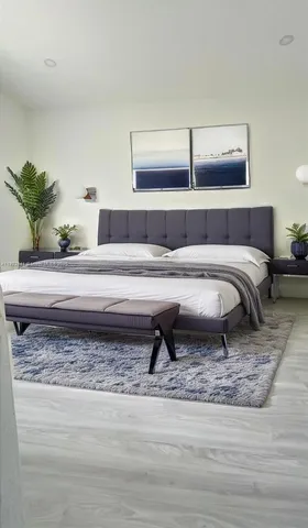 a living room with a bed and a potted plant on table